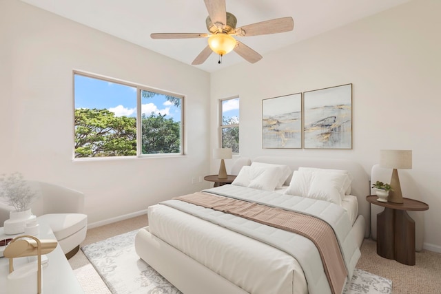 bedroom featuring ceiling fan, light carpet, and baseboards