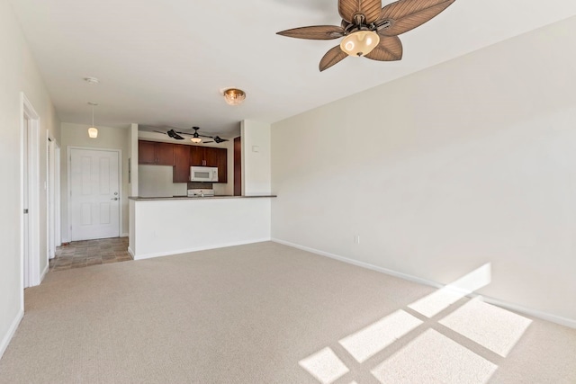 unfurnished living room featuring baseboards, light carpet, and ceiling fan