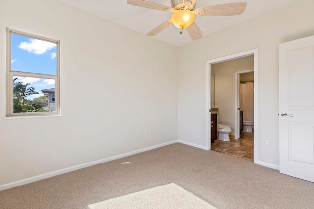 unfurnished bedroom featuring ceiling fan, connected bathroom, carpet flooring, and baseboards