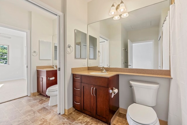 full bath with vanity, toilet, and baseboards