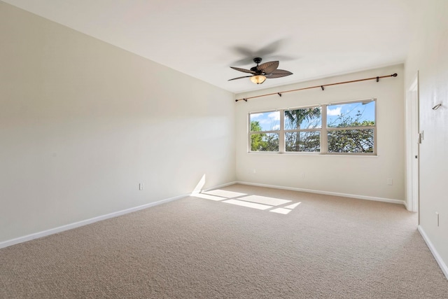 empty room featuring baseboards, a ceiling fan, and light colored carpet