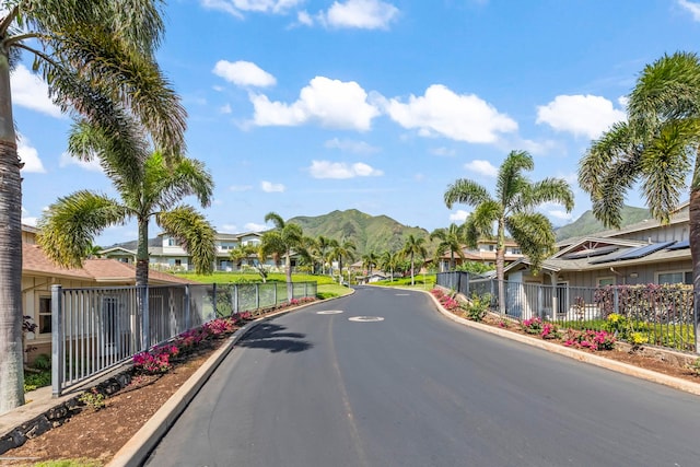 view of street with curbs, a mountain view, and a residential view