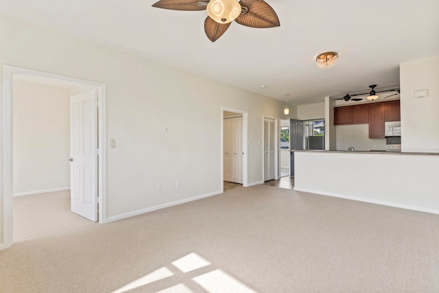 unfurnished living room with ceiling fan and light carpet