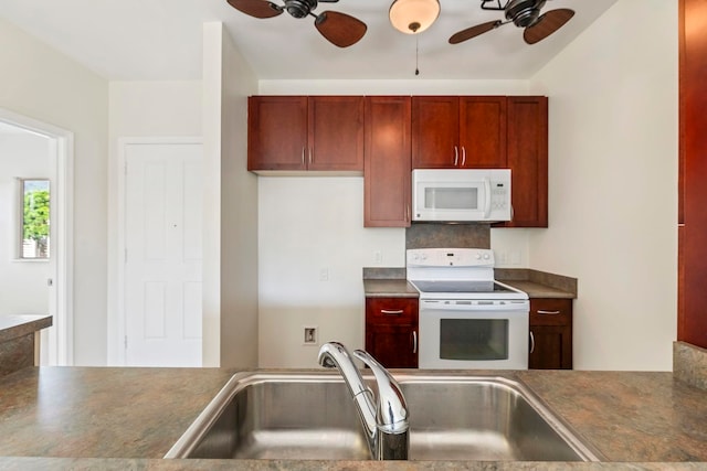 kitchen featuring a sink, tasteful backsplash, a ceiling fan, white appliances, and dark countertops