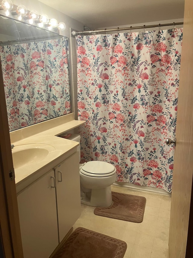 bathroom with vanity, a shower with shower curtain, toilet, and tile patterned floors