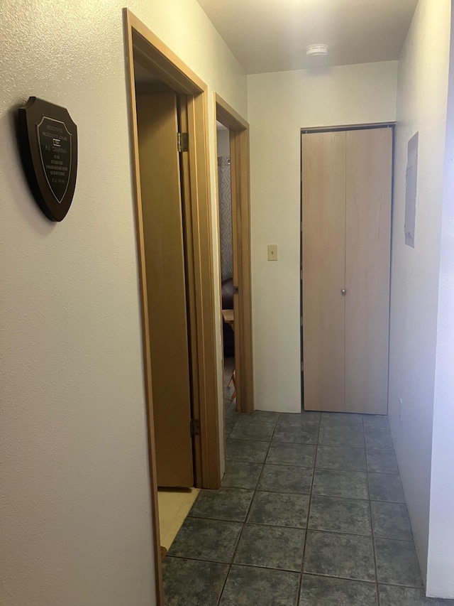 hallway featuring dark tile patterned flooring