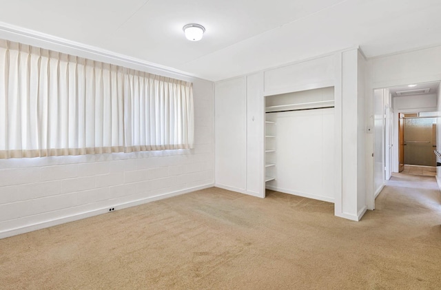 unfurnished bedroom with a closet and light colored carpet