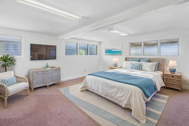 carpeted bedroom featuring concrete block wall and beam ceiling