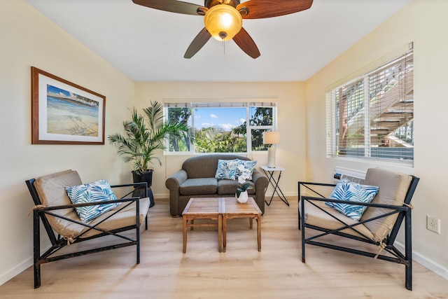 living area with light hardwood / wood-style floors and ceiling fan