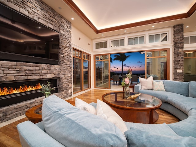 living room with hardwood / wood-style flooring, ornamental molding, and a fireplace