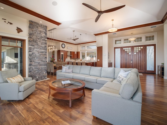 living room with a towering ceiling, hardwood / wood-style floors, and ceiling fan