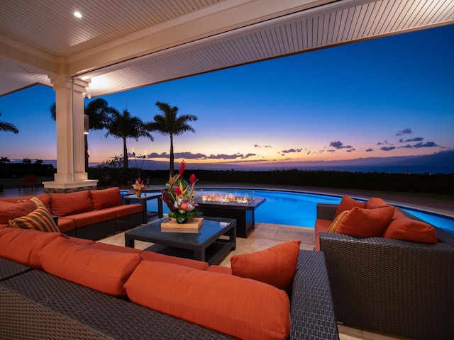 pool at dusk featuring an outdoor living space and a patio area