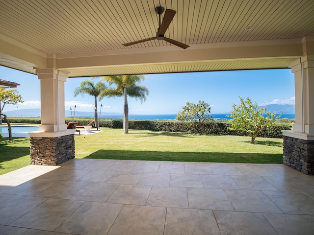 view of patio / terrace featuring a water view and ceiling fan