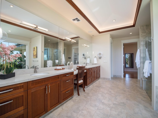 bathroom featuring a raised ceiling, vanity, and an enclosed shower