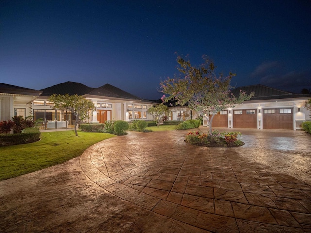 view of front of property with a garage and a yard