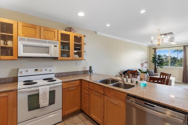 kitchen with sink, white appliances, light tile patterned floors, crown molding, and an inviting chandelier