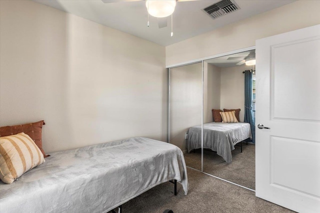 bedroom featuring dark carpet, a closet, and ceiling fan