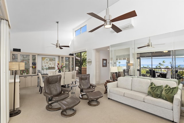 living area with light carpet, a towering ceiling, and a ceiling fan