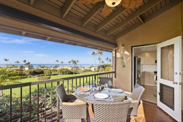 balcony with a water view and a ceiling fan