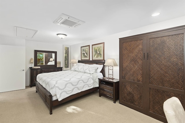 bedroom featuring attic access and light carpet