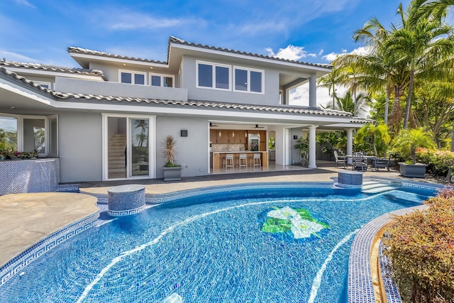 view of swimming pool with a bar and a patio