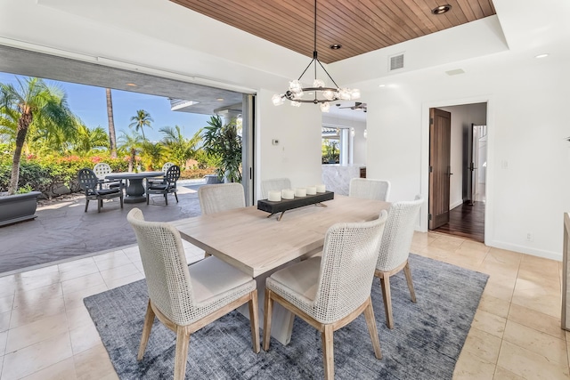 tiled dining space with wooden ceiling, a tray ceiling, and a notable chandelier