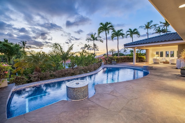 pool at dusk featuring a patio area