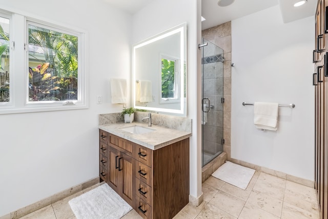 bathroom featuring a wealth of natural light, tile patterned floors, walk in shower, and vanity