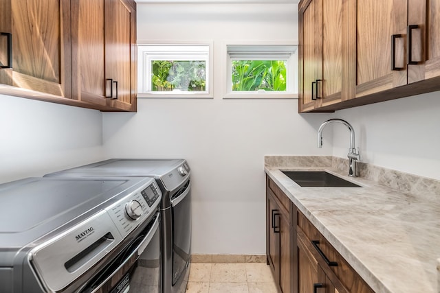 laundry area featuring cabinets, sink, and washer and dryer