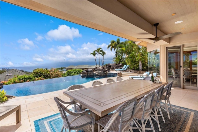 view of patio with ceiling fan and a water view