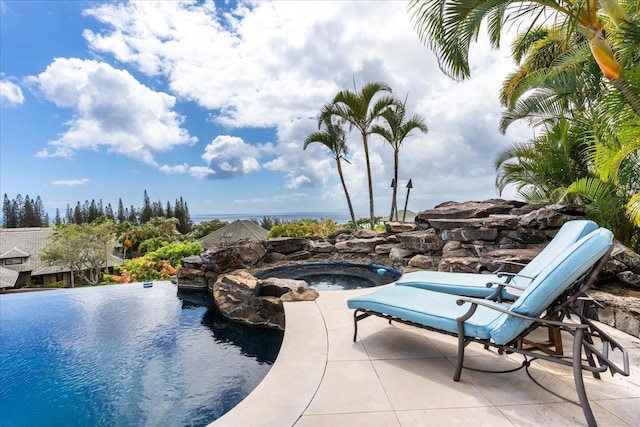 view of swimming pool with an in ground hot tub