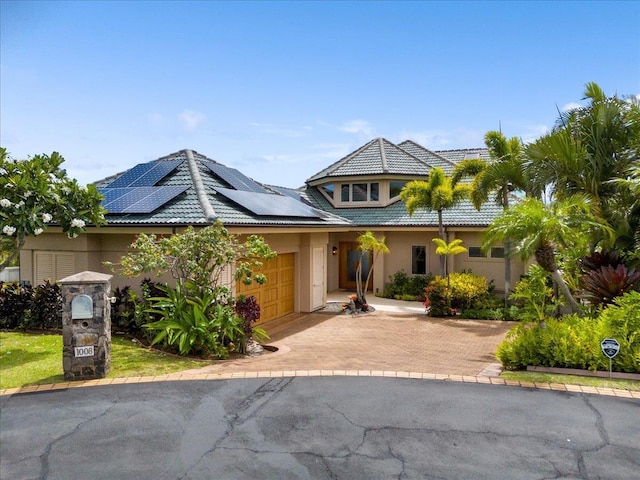 view of front of home featuring solar panels and a garage