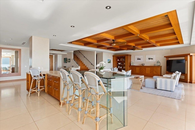 dining space with light tile patterned floors and coffered ceiling