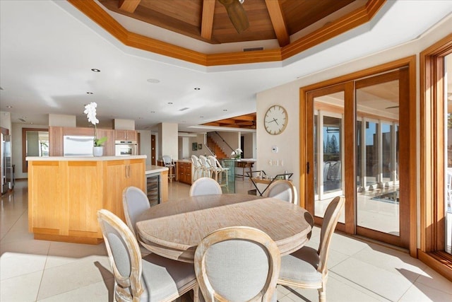 tiled dining area featuring ornamental molding, wood ceiling, and a raised ceiling