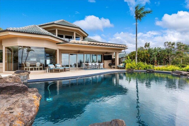 rear view of property with ceiling fan and a patio