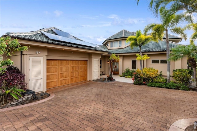 view of front of property with solar panels and a garage