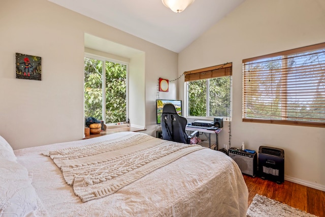 bedroom featuring lofted ceiling, dark hardwood / wood-style floors, and multiple windows