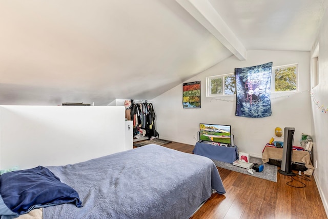 bedroom with wood-type flooring and vaulted ceiling with beams