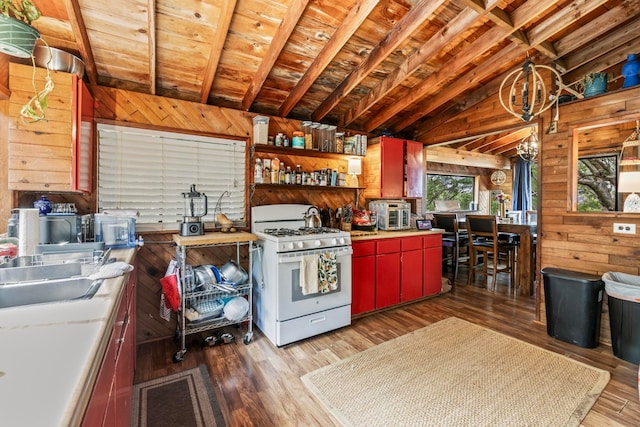 kitchen with white range with gas cooktop, vaulted ceiling with beams, wood ceiling, hardwood / wood-style floors, and wood walls