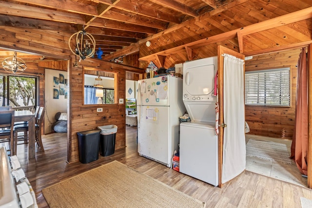 kitchen with lofted ceiling with beams, wood-type flooring, wood walls, and white fridge