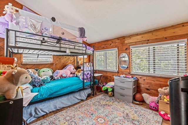 bedroom featuring wood-type flooring, vaulted ceiling, and multiple windows