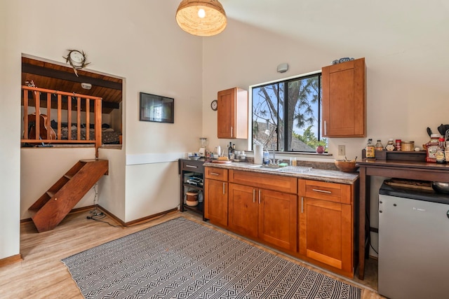 kitchen featuring high vaulted ceiling, fridge, and light wood-type flooring