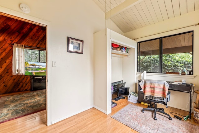 office space with light hardwood / wood-style flooring and lofted ceiling with beams