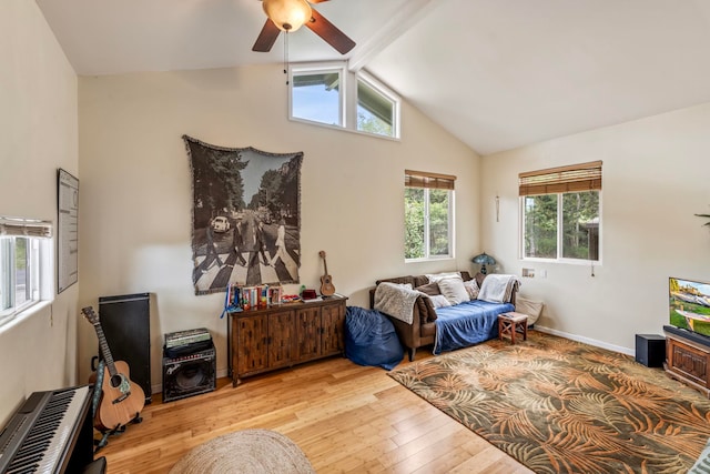 bedroom featuring beamed ceiling, light hardwood / wood-style flooring, ceiling fan, and multiple windows