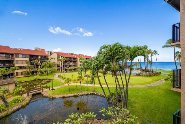 view of property's community featuring a lawn and a water view