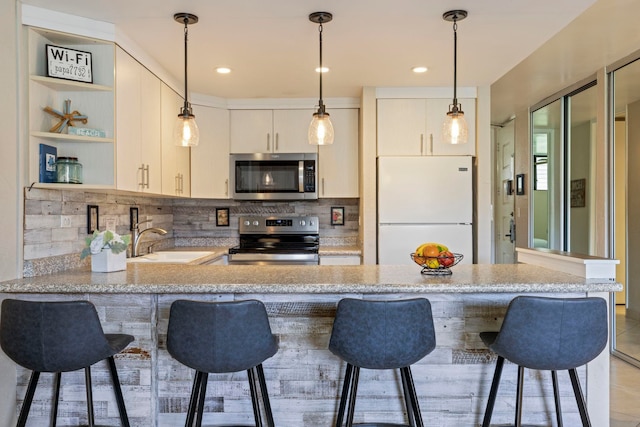 kitchen featuring backsplash, sink, a breakfast bar area, kitchen peninsula, and stainless steel appliances