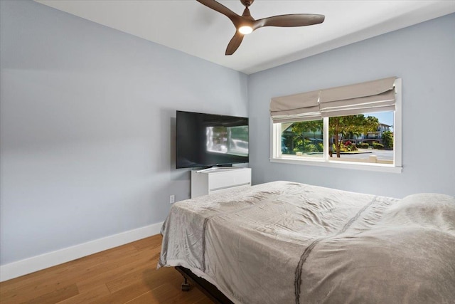 bedroom with baseboards, wood finished floors, and a ceiling fan