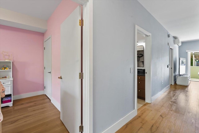 corridor featuring baseboards and light wood-style floors