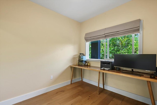 office space featuring baseboards and wood finished floors