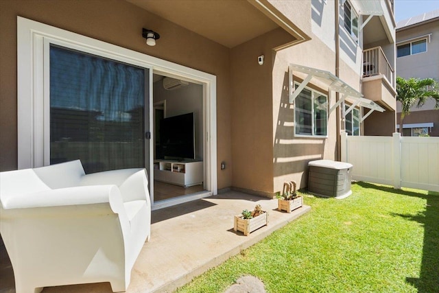 exterior space featuring a wall unit AC, stucco siding, a yard, and fence